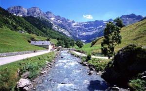 a river in the middle of a valley with mountains at luz saint sauveur doumet in Luz-Saint-Sauveur