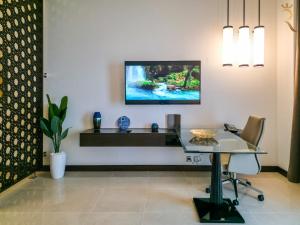 a living room with a table and a tv on the wall at Azure Crest 2BR - Ocean View Apartment Near Marina Mall in Abu Dhabi