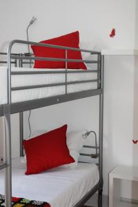 a bedroom with two bunk beds with red pillows at Hostel Rossio Alcobaça in Alcobaça