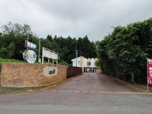 an empty street with a brick wall and trees at HOTEL i in Takahata