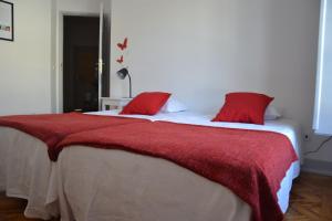 a bedroom with a large bed with red pillows at Hostel Rossio Alcobaça in Alcobaça