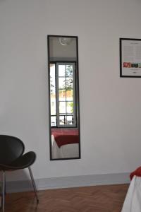 a mirror in a room with a chair and a window at Hostel Rossio Alcobaça in Alcobaça