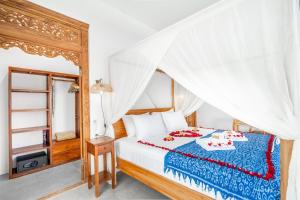 une chambre avec un lit à baldaquin dans l'établissement Villas Tirta Complex - Bingin, à Uluwatu