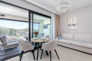 a living room with a couch and a table and chairs at Baltic View Resort&SPA Apartment 316 - Side Sea View in Międzyzdroje
