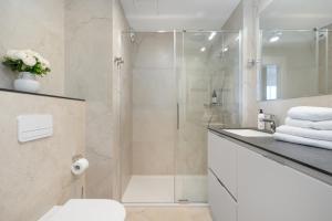 a bathroom with a shower and a toilet and a sink at Baltic View Resort&SPA Apartment 316 - Side Sea View in Międzyzdroje