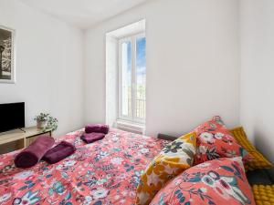 a bedroom with a bed with purple pillows and a window at Confort et charme en plein Brest, vue sur la rade in Brest