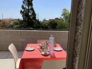 a table with a red table cloth and a bottle of water at BenitiKe House in Cala Gonone