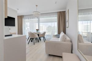 a living room with a couch and a table with chairs at Baltic View Resort&SPA Apartment 316 - Side Sea View in Międzyzdroje +37 photos