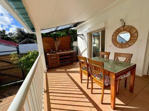 Un patio con una mesa y sillas en un balcón. en Villa OCEANE, en Sainte-Marie