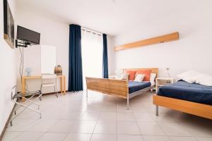 a bedroom with a bed and a couch and a television at Hotel Rosmary in Lido di Jesolo