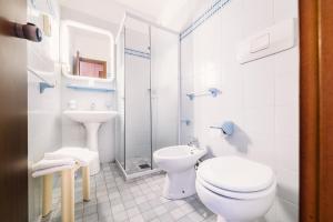 Baño blanco con aseo y lavamanos en Hotel Rosmary, en Lido di Jesolo