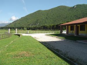 a house next to a field with a mountain at L' Antico Casale in Le Marmore