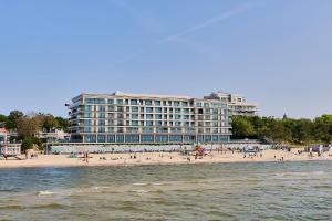 a hotel on the beach with people on the beach at Baltic View Resort&SPA Apartment 316 - Side Sea View in Międzyzdroje