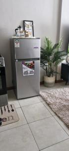 a stainless steel refrigerator in a room with a plant at The DeeLight Stay in Nairobi