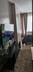 a living room with a flat screen tv and a bed at The DeeLight Stay in Nairobi
