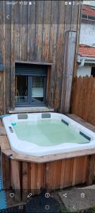 a bath tub sitting in front of a wooden fence at Océane in Gujan-Mestras