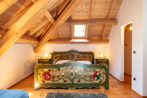 TrichianaにあるAgriturismo Fattoria Ortoalpinoの木製の天井の部屋にあるベッドのある寝室