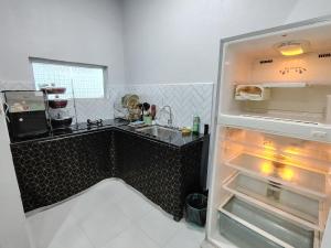 a refrigerator with its door open in a kitchen at One Lot - Villa L in Arau