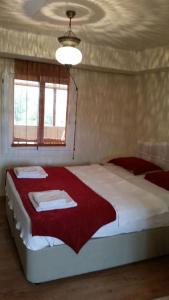 1 dormitorio con 1 cama grande con manta roja en Ephesus Selcuk Castle View Suites, en Selçuk