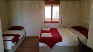 a bedroom with two beds with red and white sheets at Ephesus Selcuk Castle View Suites in Selçuk