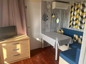 a small room with a table and a tv at Mobil Home pleine nature proche de st Guillem le désert in La Celle-sous-Gouzon