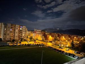 a parking lot in a city at night with buildings at Avantgarden Studio Brasov in Braşov