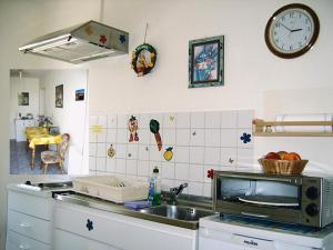 a kitchen with a sink and a clock on the wall at Ferienwohnungen "Marie" mit Terrassen, inclusive Park- und Stellplätze am Haus, Müritz-Strand nur 700m, Altstadt 10min, ruhige Lage, in Waren