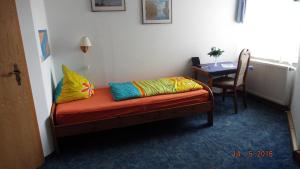 a room with a bed with colorful pillows on it at Hotel Pension zur Tanne in Zwickau