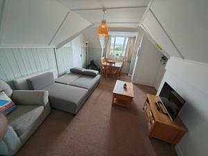 una sala de estar con un sofá y una mesa en Historic river side cottage - top apartment, en Tarring Neville