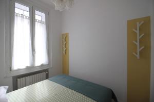 a bedroom with a bed and two windows at Appartamento La Gemma in Parma