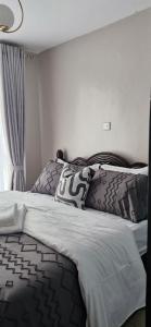 a bedroom with a bed with black and white sheets at The DeeLight Stay in Nairobi