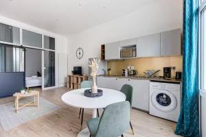 a kitchen and living room with a table and chairs at Beautiful apartment Bordeaux Tram D Croix de Seguey in Bordeaux