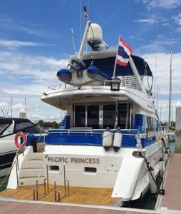 Un barco atracado en un muelle con una bandera en él. en Yacht Charter Pattaya Ocean Marina Resort, en Na Jomtien