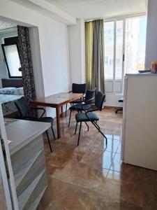 a living room with a table and chairs and a kitchen at Apartman OAZA 3 in Ulcinj