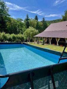 a large blue swimming pool with a gazebo at Cabana Oana 5-bedrooms chalet in Arad