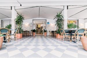 una habitación con mesas, sillas y plantas en Hotel Rosmary, en Lido di Jesolo