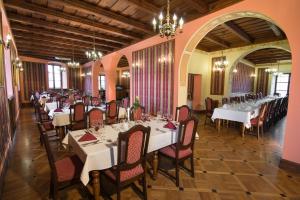 a dining room with white tables and chairs at Hotel Pod Ciżemką in Sandomierz
