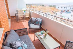 einen Balkon mit 2 Stühlen und einem Tisch auf dem Dach in der Unterkunft Casa Consorcio | +Terraza y Paseo Marítimo in Barbate
