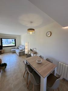 a dining room and living room with a table and chairs at El Balcón de Carrascoy, Wifi rápido, escritorio y parking ,15 min del centro de Murcia in Corvera
