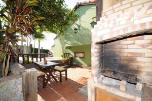 un patio de ladrillo con mesa y chimenea de ladrillo en Buzios Casa 1, en Búzios