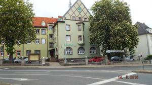ツヴィッカウにあるHotel Pension zur Tanneの通路脇の大きな黄色い建物