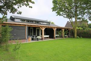 an external view of a house with a lawn at Vakantiehuis Weideblik in Biezenmortel