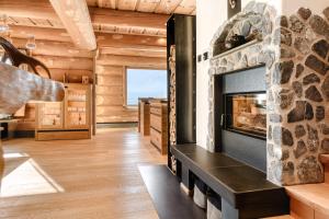 a living room with a fireplace in a log house at Sonnenchalet Bomhuesle in Dalaas