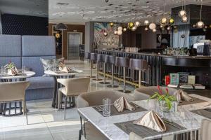 a restaurant with tables and chairs and a bar at Novotel Hotel Residences Manila by AMORE Suites in Manila