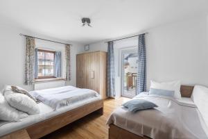 een slaapkamer met twee bedden en twee ramen bij Alte Schule in Rattendorf