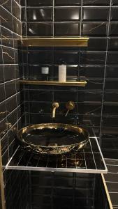 a bathroom with a sink in a black tiled wall at Spa home, Hammam in Prénouvellon