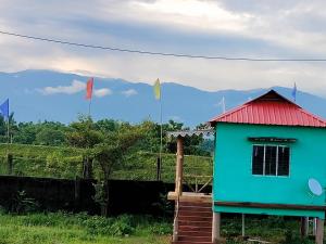 a house with a red roof and flags at Homestay Eco in Jalpāiguri