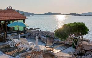 een groep stoelen en een paraplu op een steiger bij Amazing Home In Zizanj With Wifi in Otok Zizanj