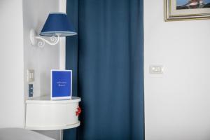 a blue curtain in a bedroom with a blue lamp at Hotel La Terrazza in Panarea