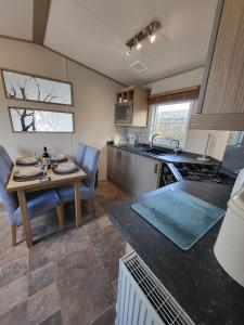 cocina y comedor con mesa y mesa en Seaview caravan, en Swanage